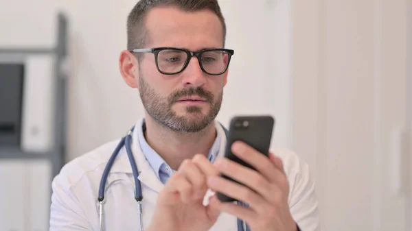 Porträtt av medelålders läkare med hjälp av smartphone — Stockfoto