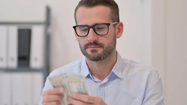 Portret van een man van middelbare leeftijd die dollars telt — Stockfoto