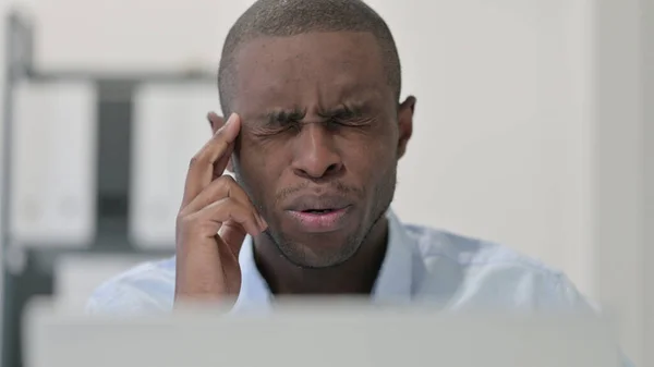 Close Up of African Man com dor de cabeça enquanto estiver usando Laptop — Fotografia de Stock