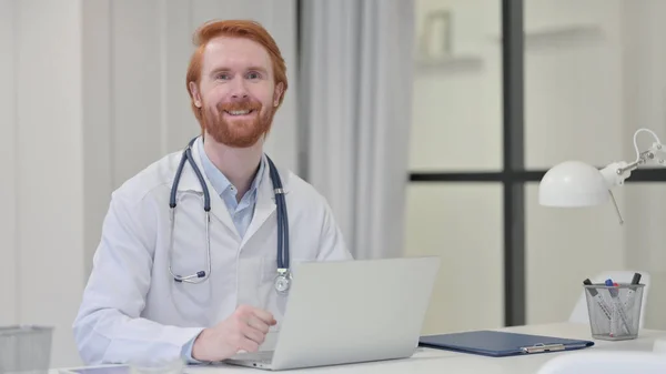 Kızıl saçlı erkek doktor Kameraya gülümsüyor — Stok fotoğraf