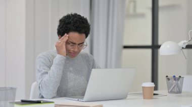 Dizüstü bilgisayar kullanırken başı ağrıyan Afrikalı Kadın 