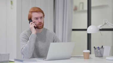 Laptoplu Sakallı Kızıl Adam Akıllı Telefonla Konuşuyor 