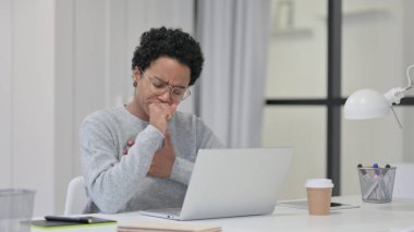 İşte dizüstü bilgisayar kullanırken öksüren Afrikalı Kadın 