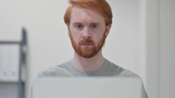 Jovem barba ruiva homem usando laptop — Fotografia de Stock