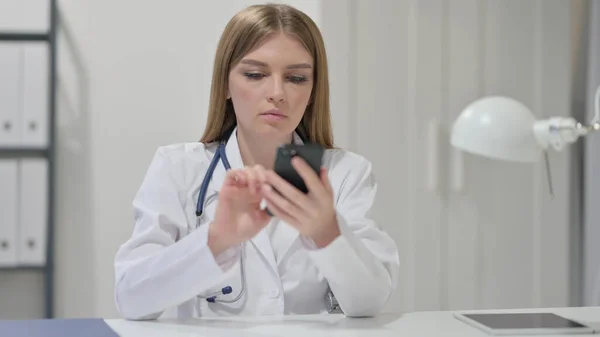 Kvinnlig läkare som använder smartphone på jobbet — Stockfoto