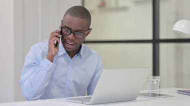 Kızgın Afrikalı adam telefonda konuşuyor, bağırıyor.