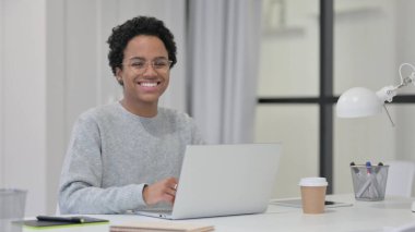 Dizüstü bilgisayarlı Afrikalı Kadın Kameraya Gülümsüyor 
