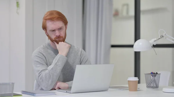 Beard Redhead Man with Laptop Thinking at Work