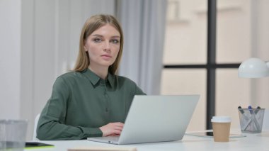 Dizüstü bilgisayarlı Genç Kadın Kameraya Bakıyor 