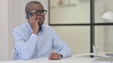 İş yerinde Afrikalı Adam Akıllı Telefonla Konuşuyor 