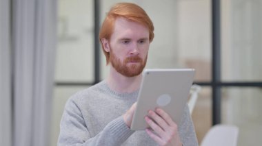 Genç Sakallı Kızıl Adam Dijital Tablet kullanıyor