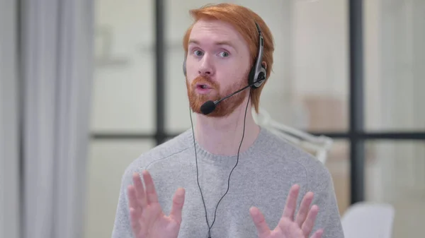 Barba rossa uomo parlando attraverso auricolare con microfono — Foto Stock