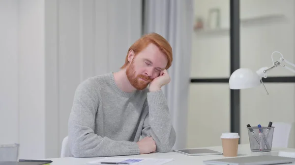 Sonolento jovem barba ruiva homem tomando a sesta no trabalho — Fotografia de Stock