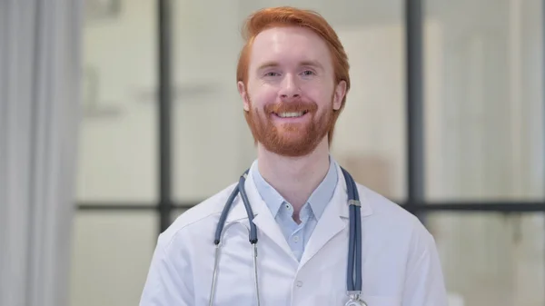 Roodharige mannelijke arts glimlachen op camera — Stockfoto
