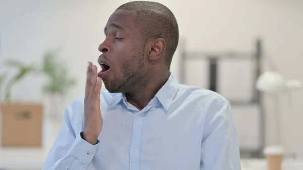 Retrato do homem africano cansado bocejando no escritório — Fotografia de Stock