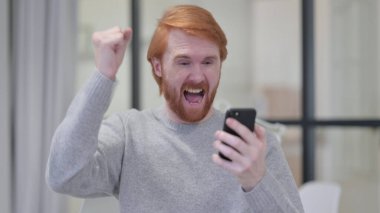 Genç Sakallı Kızıl Adam Akıllı Telefonla Kutlama Yapıyor