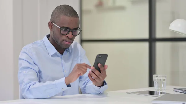 Hombre africano usando Smartphone en el trabajo —  Fotos de Stock