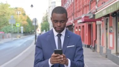 Afrikalı İşadamı sokakta yürürken Smartphone 'da Başarı Kazandı 
