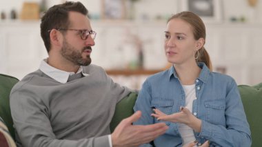 Mutlu çift koltukta otururken sohbet ediyor.