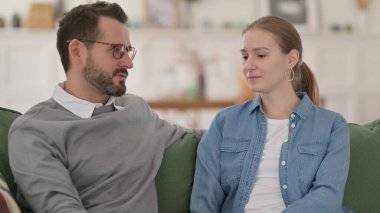 Mutlu çift koltukta otururken sohbet ediyor.