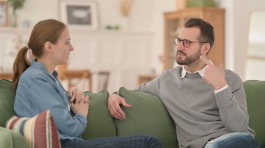 Mutlu çift koltukta otururken sohbet ediyor.