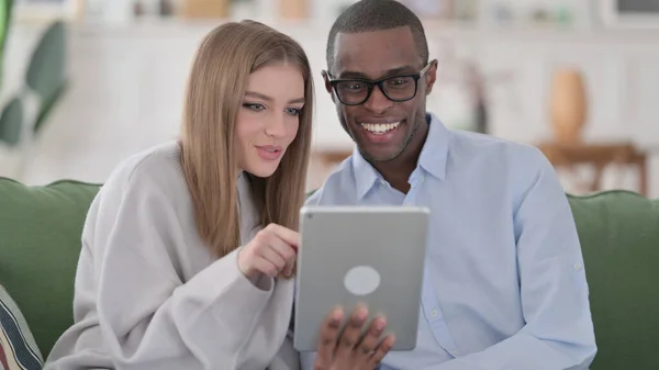 Casal Interracial feliz usando Tablet em casa — Fotografia de Stock