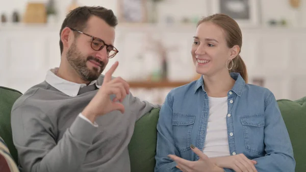 Casal tendo conversa enquanto sentado no sofá — Fotografia de Stock