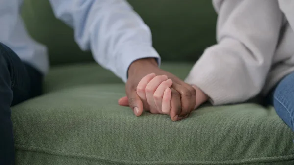 Primo piano di coppia interrazziale tenendo le mani sul divano — Foto Stock