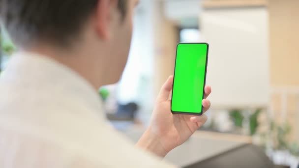 Homem jovem usando Smartphone com tela Chroma verde — Vídeo de Stock