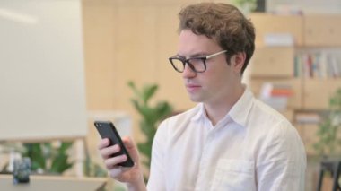 Akıllı telefon kullanan genç adamın portresi