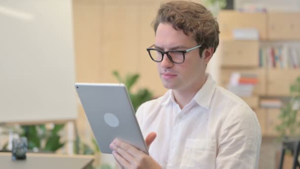 Retrato de un joven celebrando en la tableta en la oficina moderna — Vídeos de Stock