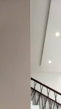 Temiz, modern bir iç tavan, tenha ışıklar ve merdiven korkulukları. Gösterişli bir mimari görünüş yaratıyor. Gayrimenkul ve ev dekorasyonu pazarlaması için ideal..