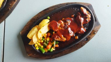 Soslu leziz bir köfte karışık sebzeler ve kırsal bir ahşap tabakta gevrek cipslerle servis ediliyor. Yemek ve restoran pazarlaması için mükemmel..