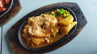 Sos ve karışık sebzeli kızarmış tavuk. Cızırdayan bir tabakta sunulan sağlıklı, iştah açıcı bir yemek. Günlük yemek ve yemek sunumu için mükemmel..