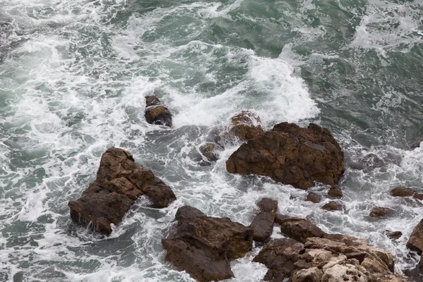 Rocas marrones y olas aplastantes — Foto de Stock