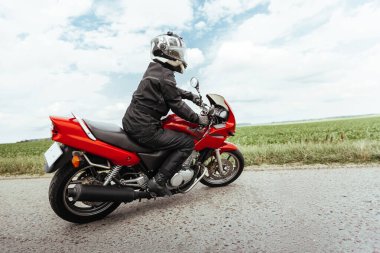 Motosikletli bir motosikletli U dönüşü yapıyor.