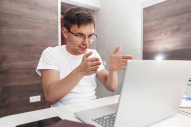 Laptop kullanan pozitif genç adam görüntüsü.