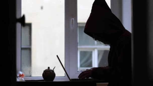 Mann mit Kapuze tippt auf Laptop-Hacker — Stockvideo