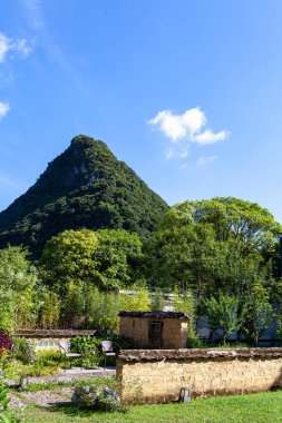 Yazın güzel kırsal alanların manzarası. Ormanlı dağları ve mavi gökyüzünün altında çimenli bir arazisi olan güzel bir manzara.