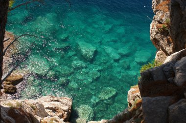 masmavi deniz, bir gözyaşı su, taş kayalık sahil şeffaf