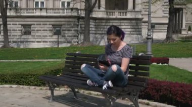 Yaratıcı öğrenci kız yeşil bir parkta bir tablet pc ile çalışma