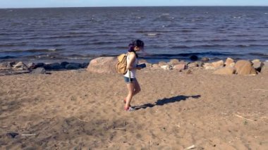Ağır çekimde sahilde yürüyen mutlu kadın