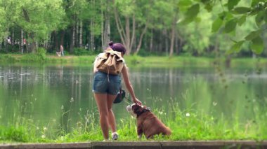 Bir gölün yanında bir bulldog olan kadın