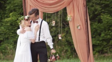 damat ve gelin kemer altında bir buket ile