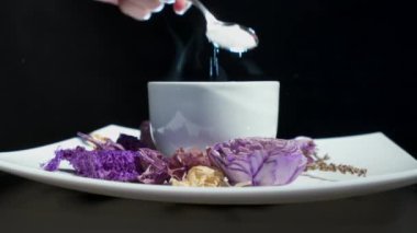 Şeker fincan çay için dönen çiçeklerle ekleyerek.