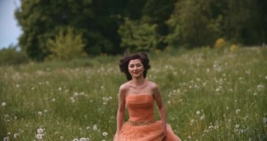 Yaz tarlasında ağır çekimde koşan güzel Asyalı bir gelinin portresi. Çiçek çayırında giyinmiş güzel mutlu bayan. Güzellik ve özgürlük kavramı.