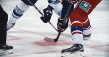 Buz hokeyi şampiyonluğu. Oyuncu top sürüyor. Disk bulundurmaktan. Kış sporu kavramı. Profesyonel lig yarışması. Açık stadyumda sopalarla oynayan tam teçhizatlı adamlar..