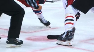 Buz hokeyi şampiyonluğu. Oyuncu top sürüyor. Disk bulundurmaktan. Kış sporu kavramı. Profesyonel lig yarışması. Açık stadyumda sopalarla oynayan tam teçhizatlı adamlar..