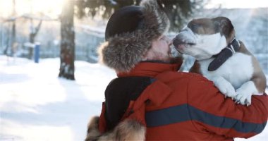 Genç sakallı adamın sevimli arkadaşına sarılıp nazikçe öptüğü bir sahne. Portreci çocuk, kışın dışarıda saf köpeğiyle eğleniyor. Hayvanlar, hayvanlar, insan dostluğu