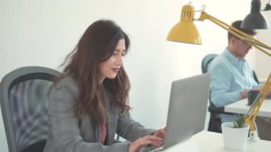 Mutlu Milenyum Asyalı etnik köken kız öğrencileri. İnternette laptop kullanan bir iş kadını. Güzel, güler yüzlü, kendine güvenen genç bir kadın başarılı bir ticaret operasyonu yaptı. Kadın işçi ev ofisindeki ekrana bakıyor..